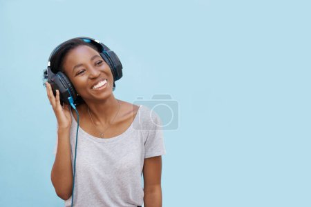 Téléchargez les photos : Happy, musique et femme noire avec écouteurs en studio pour streaming, son ou podcast sur fond bleu. Rappelez-vous, sourire et gen z étudiant avec écouteurs, réflexion ou idée, nouvelles auditives ou radio. - en image libre de droit