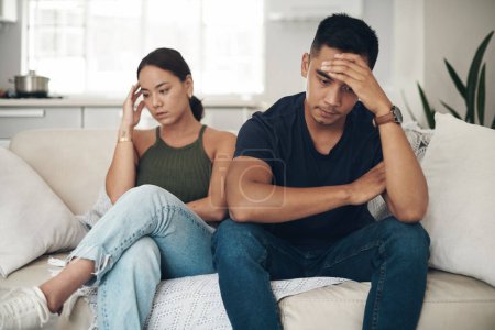 Divorce, stress or couple fight on sofa with headache, anxiety or frustrated by liar, fail or drama at home. Marriage, conflict or asian people argue in living room with fear, overthinking or mistake.
