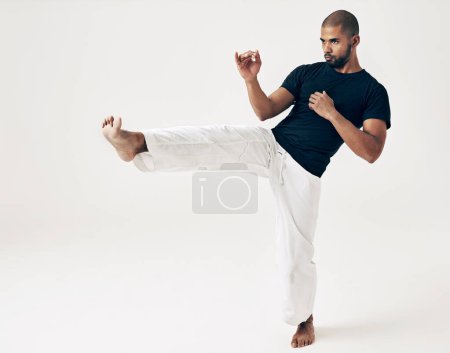 Photo for Man, studio and karate for kick practice, action and martial arts on white background. Black male person, mockup space and training for combat, fight and position of attack in taekwondo for fitness. - Royalty Free Image