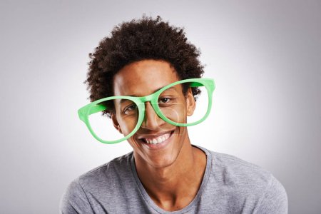 Portrait, black man or glasses as funny, joke or vision of comic, customer or service in studio. Plastic eyewear, male person or smile at goofy, visual or humor of ophthalmology on grey background.