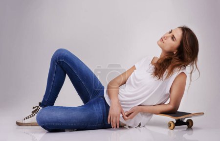 Photo for Woman, skateboard and relaxed in studio dreaming of adventure, travelling and exploring skatepark. Person, thinking and resting on board for sports, health or freedom . and cruising on the road. - Royalty Free Image