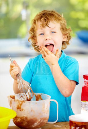 Photo for Portrait, messy or boy as eating, chocolate or baking as fun, meal prep or holiday activity in home. Naughty, male child or whip to lick, dough or food mixture by learning, nutrition or wellness. - Royalty Free Image