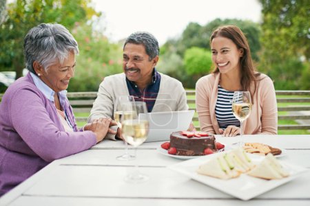 Photo for Senior, couple and romance, outdoor and tablet for celebration of anniversary of parents with champagne. Summer, relax and weekend, cake and lunch for brunch in backyard or garden, woman and family. - Royalty Free Image