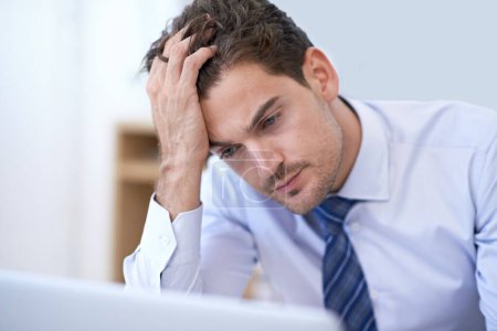 Photo for When work just becomes too much...A young businessman looking frustrated at the office - Royalty Free Image