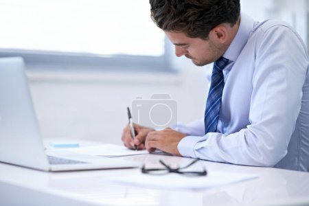 Photo for And the deal is done. Shot of a businessman working at his desk - Royalty Free Image
