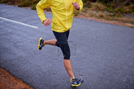 Photo for Cold, legs and man with fitness, running and challenge with endurance and energy with morning cardio. Person, runner or athlete with sneakers, wellness or wet road with hobby, winter or stress relief. - Royalty Free Image
