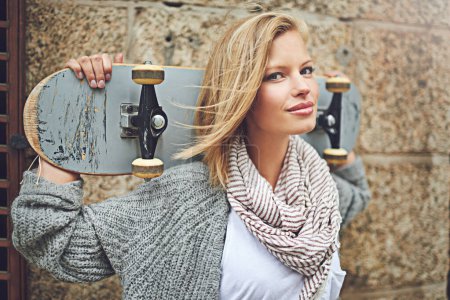 Photo for Portrait, skateboard and woman in a city, wall and confidence with hipster and fitness. Face, happy person and outdoor with skater and competition with skills and talent with hobby and fun activity. - Royalty Free Image