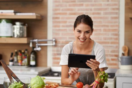 Photo for Online, woman and cooking with recipe on tablet in kitchen to watch tutorial video with instructions. Learning, guide and person reading healthy food info on mobile app in home to diet with nutrition. - Royalty Free Image