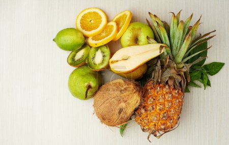 Group, tropical and fruit on table for health, smoothie and vegan diet by light background with coconut. Pear, kiwi and vitamin c with nutrition on wood surface for weight loss, milkshake and energy.