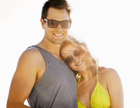 Photo for Happy, couple and smile on vacation by beach with sunglasses, hug and holiday for memories or honeymoon. Woman, man and relationship at destination by ocean for trip, getaway or weekend for bonding. - Royalty Free Image