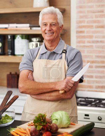 Photo for Senior man and arms with knife in kitchen or confident, tomato and carrots for diet. Male chef and portrait with healthy vegetables for nutrition, peeling green lettuce with onion in retirement home. - Royalty Free Image