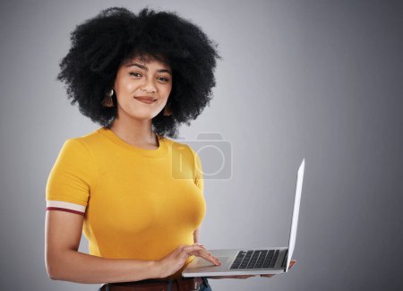 Photo for Black woman, laptop and portrait in studio for copywriting article on hair care tips, advice and growth. Curly girl or copywriter typing on computer with natural texture or style on gray background. - Royalty Free Image