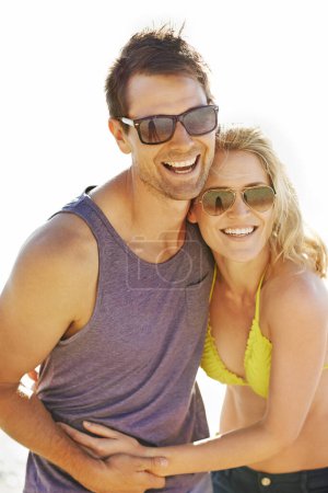 Photo for Happy, couple and laugh on vacation by beach with sunglasses, hug and holiday for memories or honeymoon. Woman, man and relationship at destination by ocean for trip, getaway or weekend for bonding. - Royalty Free Image