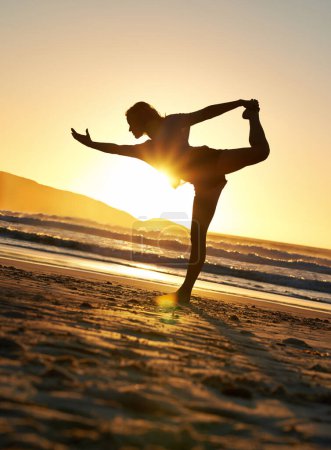 Foto de Yoga, mujer o equilibrio en la playa del atardecer para el bienestar, relajarse con zen para la mentalidad de salud. Instructora o cielo con océano para la paz espiritual, destello de lente y libertad en la arena con fe para el ejercicio. - Imagen libre de derechos
