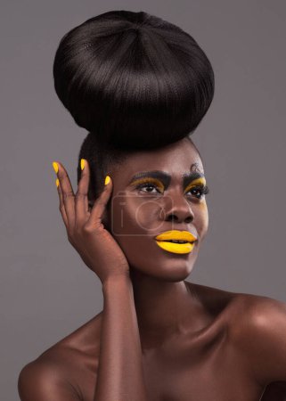 Téléchargez les photos : Art africain, mannequin et studio avec maquillage, beauté et rouge à lèvres jaune créatif. Chauves, femme et peau en toute confiance, cheveux et brioches spectaculaires pour des cosmétiques glamour ou tendance isolés sur fond gris. - en image libre de droit