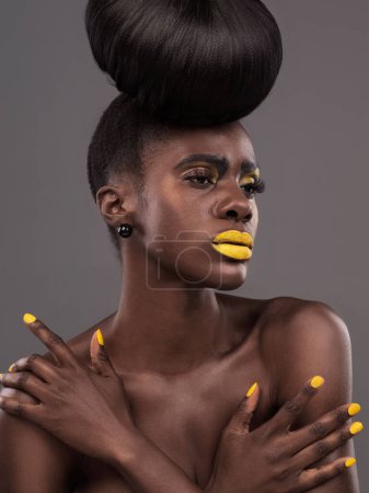 Photo for African, model and studio color with makeup, beauty and creative yellow lipstick. Bold, woman and skin with confidence, dramatic hair and bun for glamour and trendy cosmetics on grey background. - Royalty Free Image