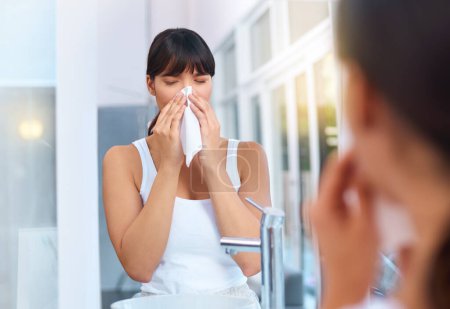 Photo for Woman, sick and allergies in bathroom for healthcare, virus and illness in morning for weather change. Asian female person, cough and tissue for sneezing, flu and reflection of medical problem - Royalty Free Image