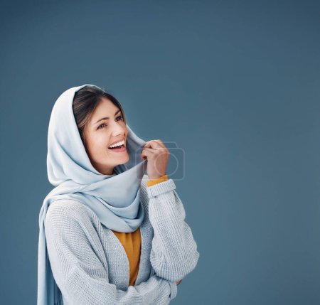 Photo for Thinking, fashion and happy muslim woman with dream in studio isolated on a blue background mockup space. Hijab, smile and person with idea in stylish casual clothes for vision, decision or laughing. - Royalty Free Image