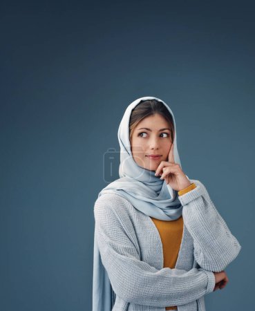 Téléchargez les photos : Mode, pensée et femme musulmane avec idée en studio isolé sur un fond bleu espace maquette. Personne sérieuse, rêveuse et islamique dans le hijab pour la vision, l'inspiration ou la décision avec des vêtements décontractés. - en image libre de droit