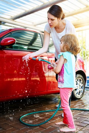 Photo for Mom, girl and washing car with teaching or learning for child development, growth and childhood memories. Parent, kid and enjoy with bonding, fun and educational with support and recreational at home. - Royalty Free Image