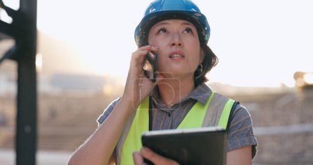 Photo for Asian woman, phone call and tablet, construction worker and inspection of building site for project management. Architecture, engineer and communication, contractor and affirmative action outdoor. - Royalty Free Image