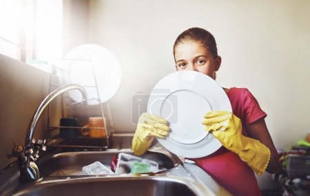 Téléchargez les photos : Portrait, vaisselle ou chevreau avec assiette et gants dans un évier de cuisine à la maison pour une hygiène saine. Apprentissage, développement ou nettoyage des filles avec de l'eau ou du savon pour désinfecter le désordre, les bactéries ou les germes. - en image libre de droit