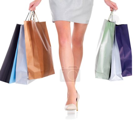 Photo for Legs, shopping bags and woman with gifts in studio for deal, sale or discount for luxury. Paper packet, presents and closeup of female person feet with heels for fashion isolated by white background - Royalty Free Image