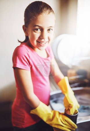 Photo for Portrait, washing dishes or girl with dirty cup or gloves in kitchen sink in home for healthy hygiene. Happy, development or kid cleaning with soap to disinfect plates of mess, bacteria or germs. - Royalty Free Image