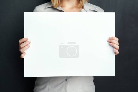 Photo for Studio, woman and hands with paper for advertising poster, design or marketing info on mockup. Female person, banner and plank board with space for news, promotion and branding on black background. - Royalty Free Image