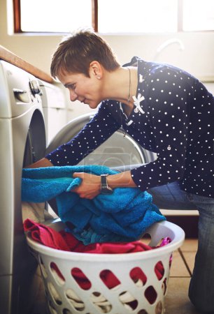 Photo for Woman, washing machine and clothes laundry in home for spring cleaning morning, hygiene or detergent. Female person, basket and housekeeping work with electrical appliance or task, sanitary or towels. - Royalty Free Image