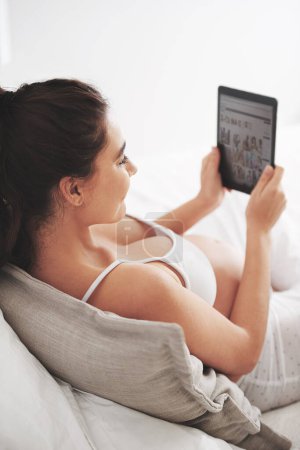 Schwangerschaft, Frau und Tablet-Bildschirm im Bett für soziale Medien, Mutterschaftsforschung und -planung. Mutter, entspannen und Ideen mit digitaler Technologie für Website, Mutterschaft Blog und Informationen zu Hause.