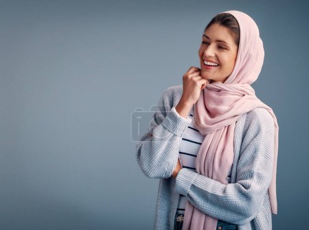 Foto de Moda, mujer y hijab en estudio, sonrisa y aislado sobre fondo gris. Bufanda en la cabeza, Ramandan y elegante para el modelo femenino árabe religioso, musulmán o espacio de maqueta para el minimalismo traje islámico Eid. - Imagen libre de derechos
