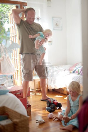 Photo for Father, child and smile in home with stress or overwhelmed parenting for hyperactive adhd, siblings or development. Male person, daughters and laughing in bedroom as single dad, toys or housework. - Royalty Free Image