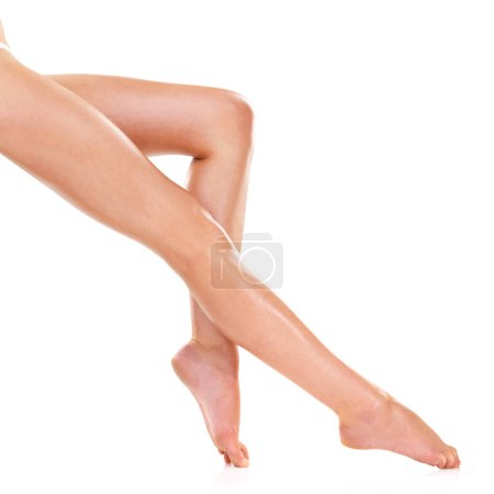 Photo for Legs, skin and beauty of feet in studio for shaving, cleaning or waxing for grooming isolated on a white background. Foot, knee and person in epilation, pedicure and natural hair removal treatment. - Royalty Free Image