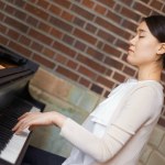 Piano, musician or calm woman in home for music training for an artistic classical performance for peace. Creative lady, relax or Asian person playing a song for learning practice routine in Japan.