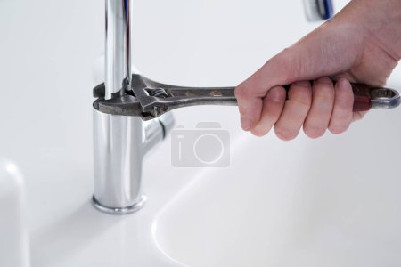 Photo for Handyman, plumbing and tools in kitchen sink with wrench, pipes and repair at work and job in home. Male person, artisan and worker for client in house for fitting, installing or fixing water system. - Royalty Free Image