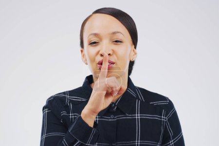 Woman, portrait and gesture with secret, studio and silence for mystery announcement. Model, gossip and hush with rumor, whisper and finger on lips for news or noise with privacy on white background.