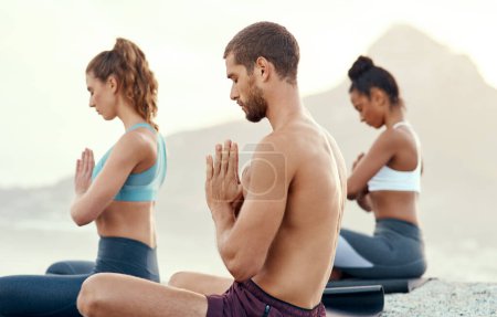 Téléchargez les photos : Fitness, méditation et yoga avec des personnes sur la plage pour la santé mentale, la paix ou le bien-être le matin. Exercice, entraînement et zen avec des amis sportifs sur le tapis au bord de l'océan pour l'équilibre et l'état d'esprit. - en image libre de droit