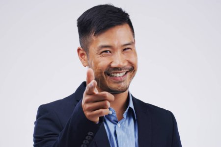 Photo for Portrait, smile and Asian man pointing at you for choice, business decision and face isolated in studio. Direction, selection or hand gesture for opportunity, hr or hiring on a white background space. - Royalty Free Image