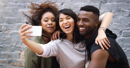 Photo for Diversity, selfie and social media with friends on brick wall background in city for profile picture. App, happy or smile with man and woman group outdoor together for bonding, fun or photography. - Royalty Free Image