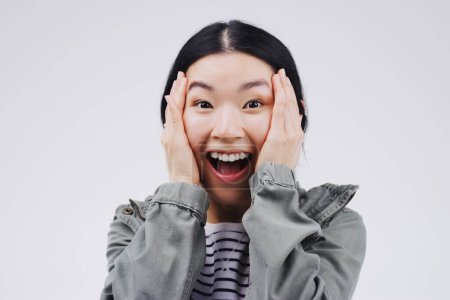 Studio background, surprise and asian woman in portrait with mockup space, wow and mind blown with good news. Happy, female person and omg reaction for announcement, lottery or competition prize.