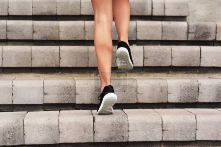 Athlete, feet and run for person on stairs, exercise and training for marathon competition. Runner, sports and workout for wellness and health on steps, cardio and footwear for endurance hit fitness.