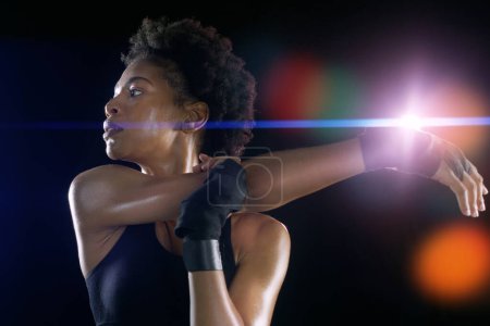 Photo for Black woman, arm and stretching as warm up workout on dark background or night, healthy or athlete. Female person, morning and exercise training for running marathon or mobility, studio or mockup. - Royalty Free Image