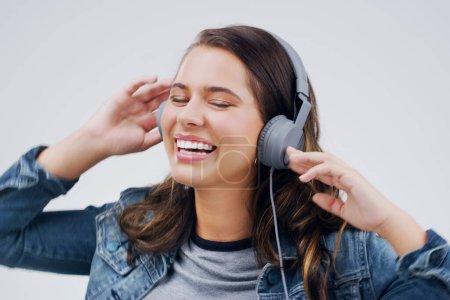 Photo for Headphones, dance or happy woman streaming music in studio for singing on grey background to relax. Model, podcast or girl listening to radio playlist, sound or song audio on an online subscription. - Royalty Free Image
