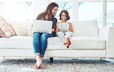 Photo for Laptop, tablet and mother with child on sofa for streaming movies, happiness and bonding together in living room. Family, mom and young girl with technology for watching videos, film or relax in home. - Royalty Free Image