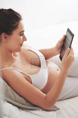 Photo for Pregnant, woman and relax with tablet on bed for maternity planning, research or communication. Happy, mother and smile with technology for motherhood website, pregnancy blog and information at home. - Royalty Free Image