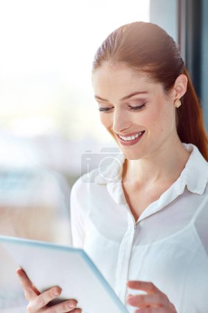 Téléchargez les photos : Femme d'affaires, tablette et sourire sur le lieu de travail pour l'étude de marché, le développement et le réseautage. Technologie, en ligne et étude en bureau pour start-up, projet et défilement sur les médias sociaux - en image libre de droit
