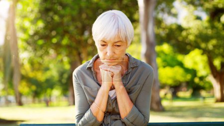 Photo for Old woman, praying or thinking in park, sad with grief or loss, dementia diagnosis and health scare with faith or reflection. Hope, memory or depressed with worship, nostalgia or regret with religion. - Royalty Free Image