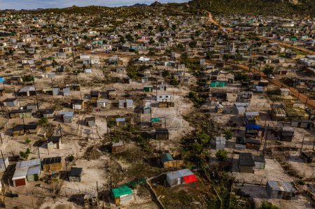 Rural, township and poverty with shacks, houses or informal settlement of land or squatter camps in South Africa. Aerial view of village, housing or poor infrastructure of town or developing country.