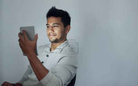 Photo for Night, smile and tablet with business man on space in studio for communication, networking or streaming. Mockup, relax and technology with happy young employee on gray background for research. - Royalty Free Image